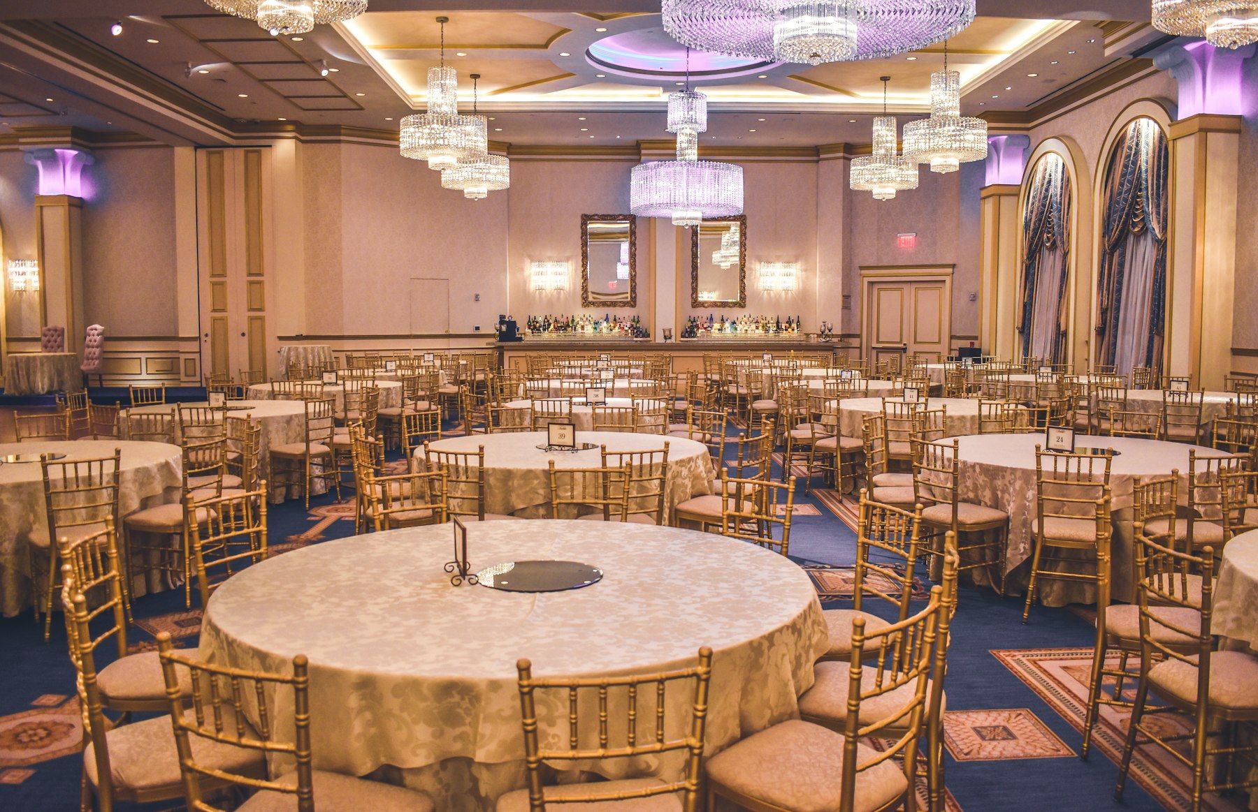 Salón de fiestas con mesas redondas listo para un evento